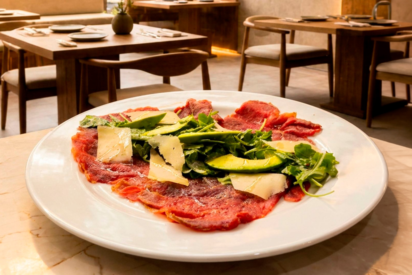Carpaccio de res con arúgula, aguacate y parmesano